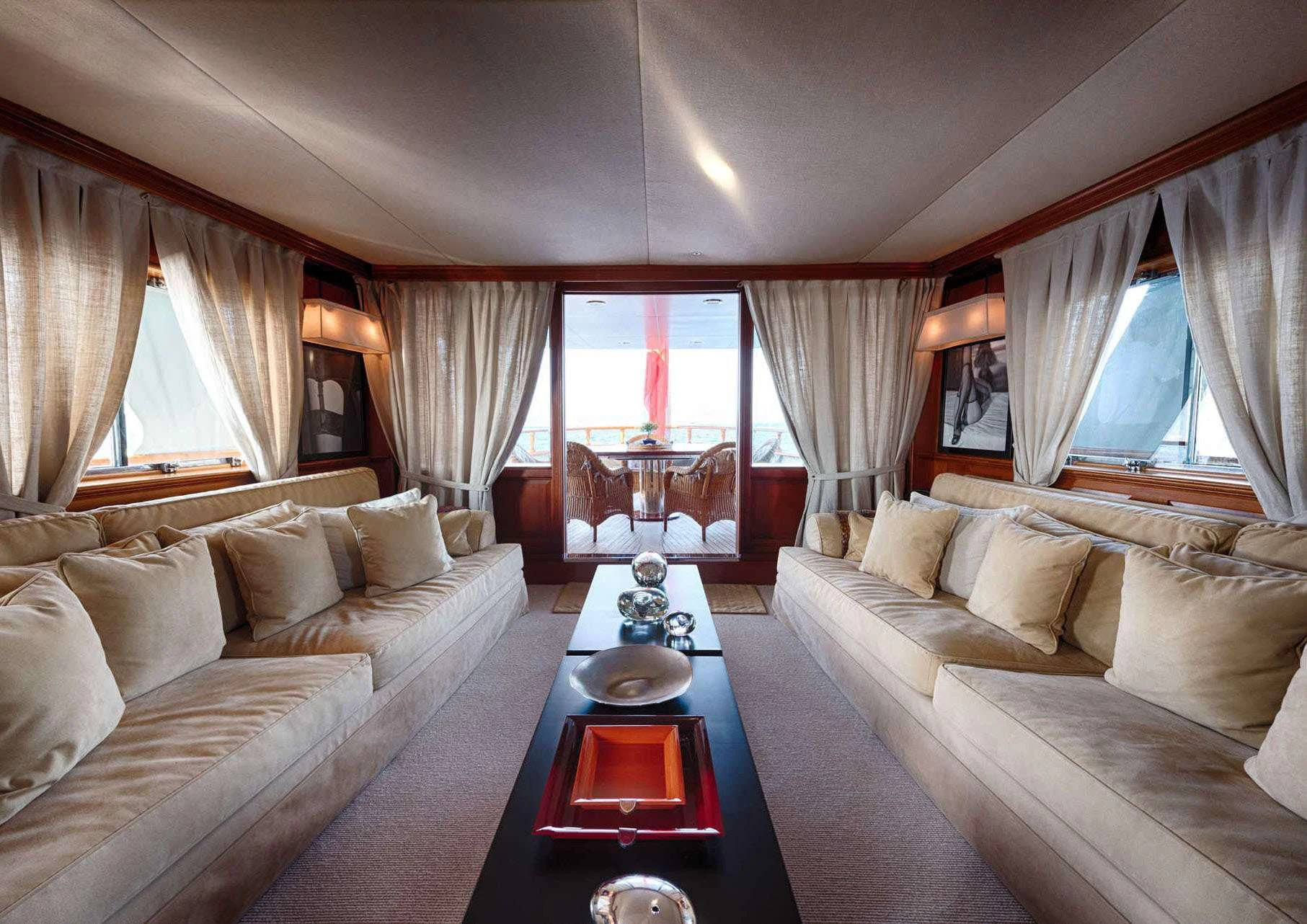 a living room with a table and couches aboard JURA II Yacht for Sale