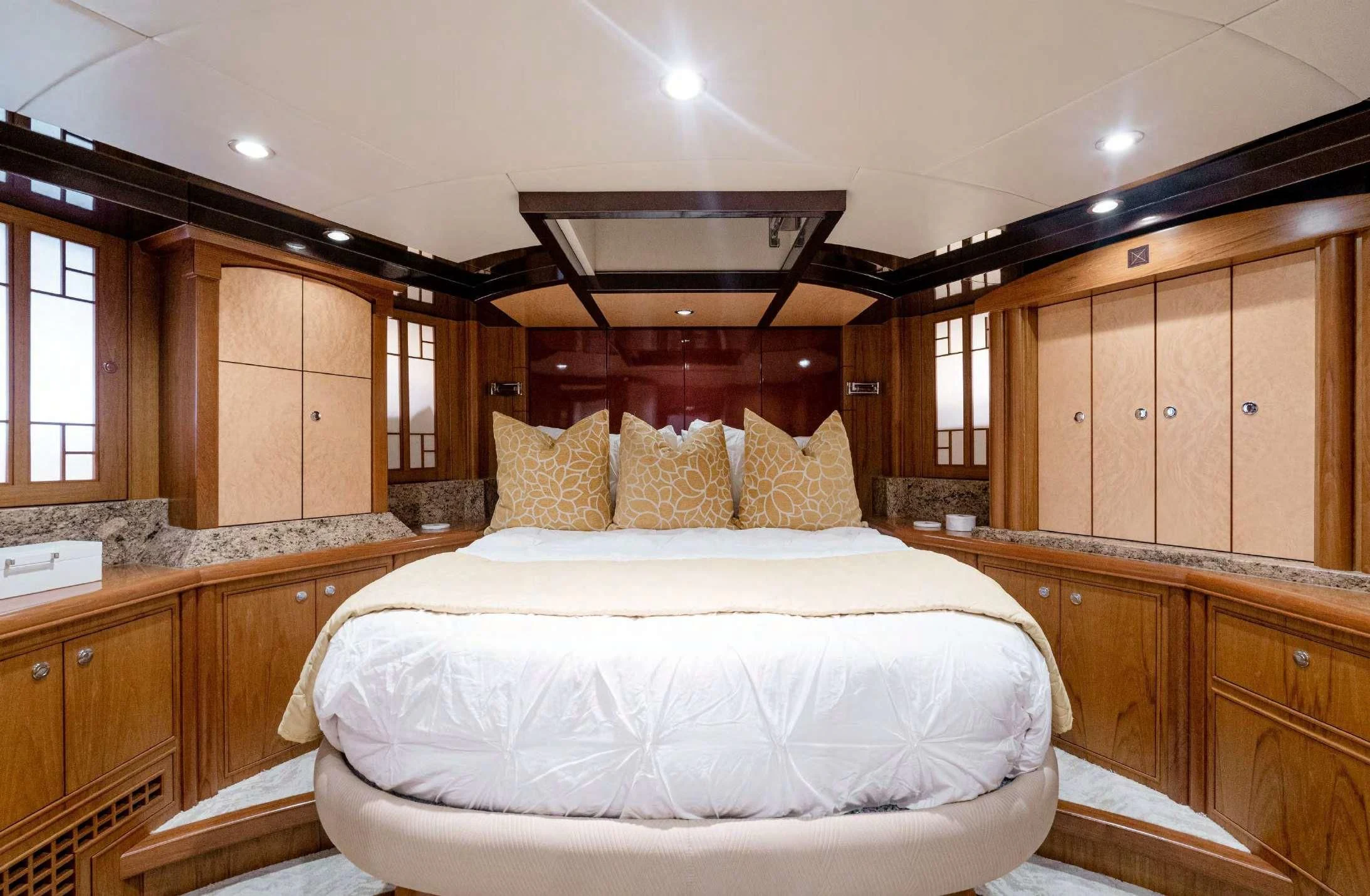 a bedroom with wooden cabinets aboard HAPPINESS II Yacht for Sale