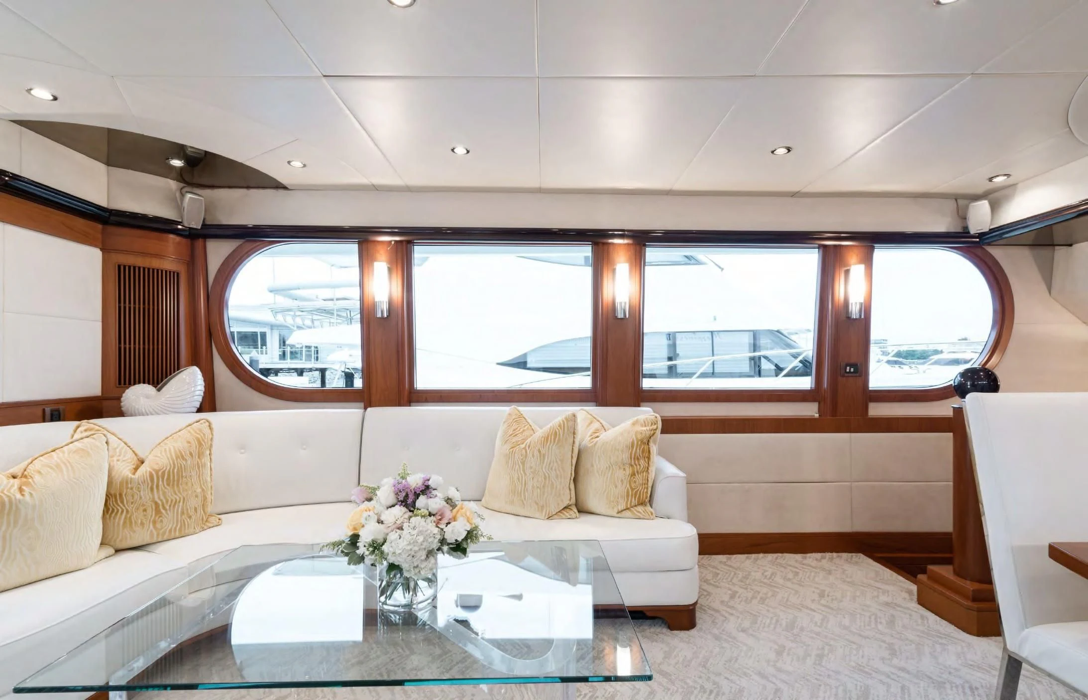 a room with a couch and a table with flowers on it aboard HAPPINESS II Yacht for Sale