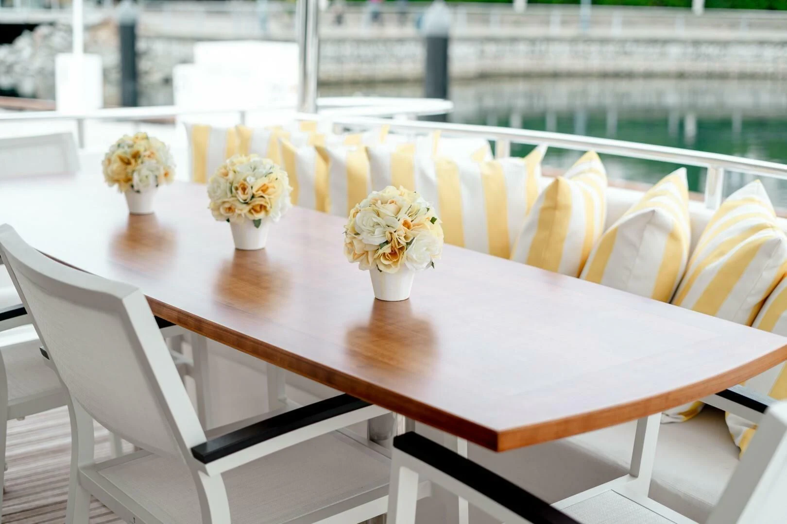 a table with white chairs and yellow flowers on it aboard HAPPINESS II Yacht for Sale