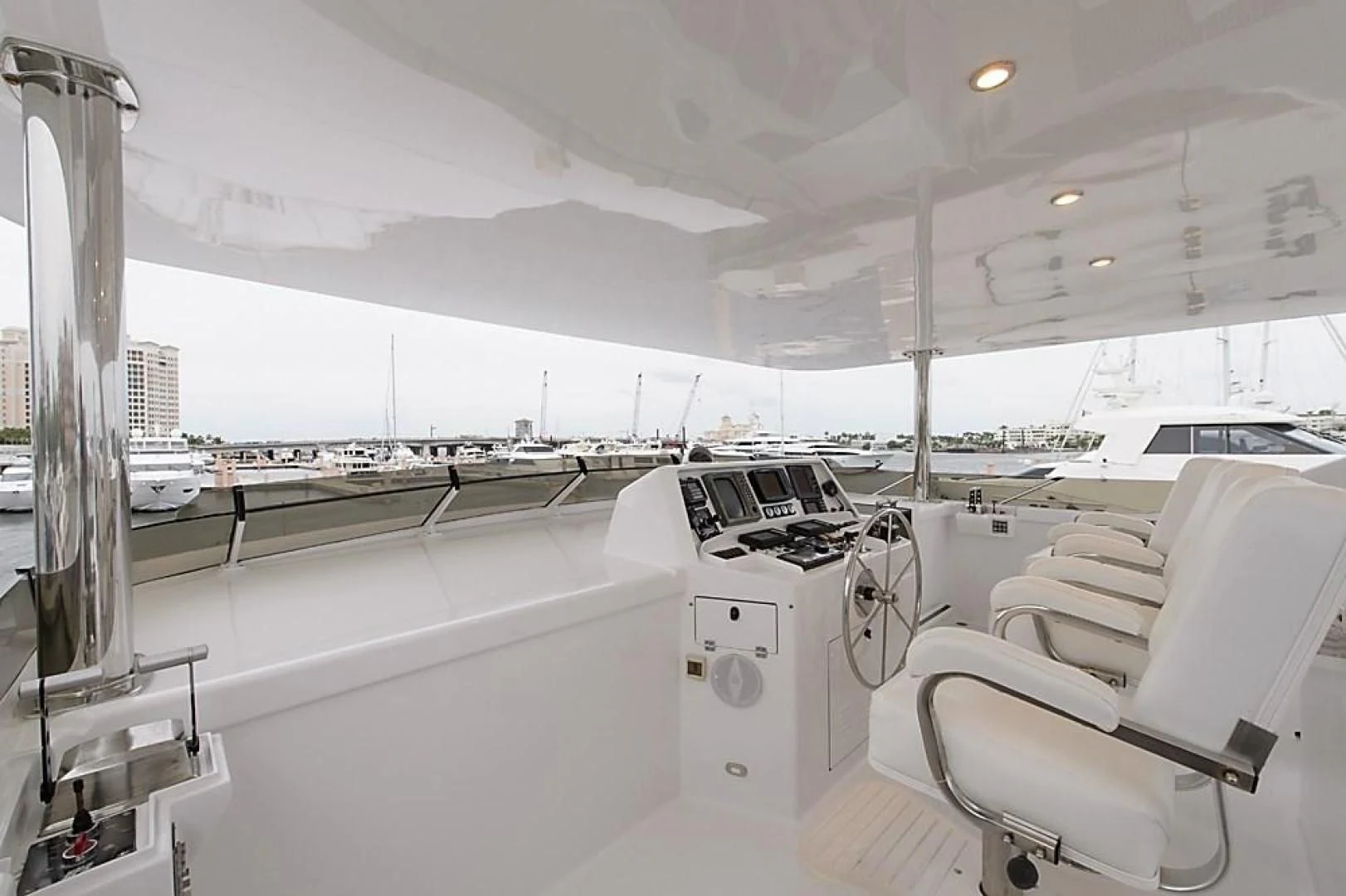 a room with white chairs and a large window with a view of the city aboard MALDAU Yacht for Sale