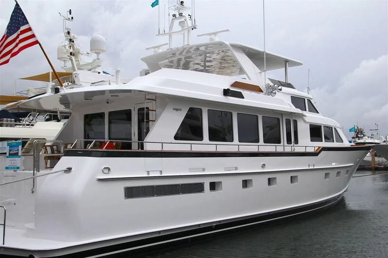 a white boat with a flag on top aboard MALDAU Yacht for Sale
