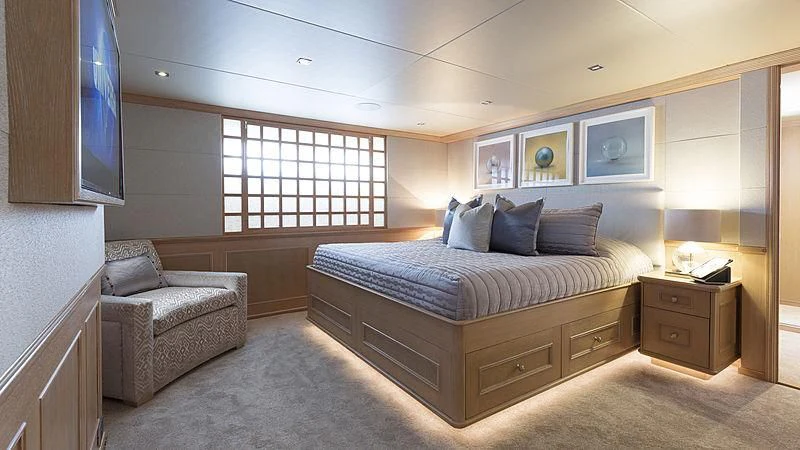 a bedroom with a bed and a chair aboard ENDEAVOUR 2 Yacht for Sale