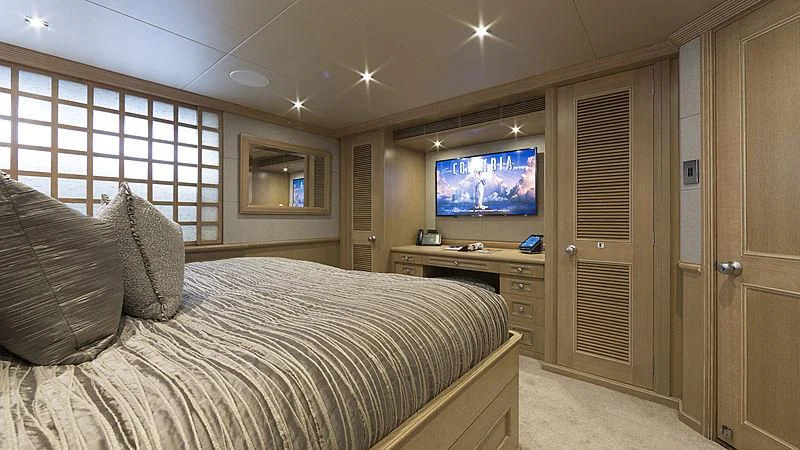 a bedroom with a bed and a tv on the wall aboard ENDEAVOUR 2 Yacht for Sale