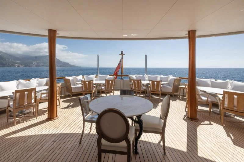 a table and chairs on a deck overlooking a body of water aboard WEDGE TOO Yacht for Sale