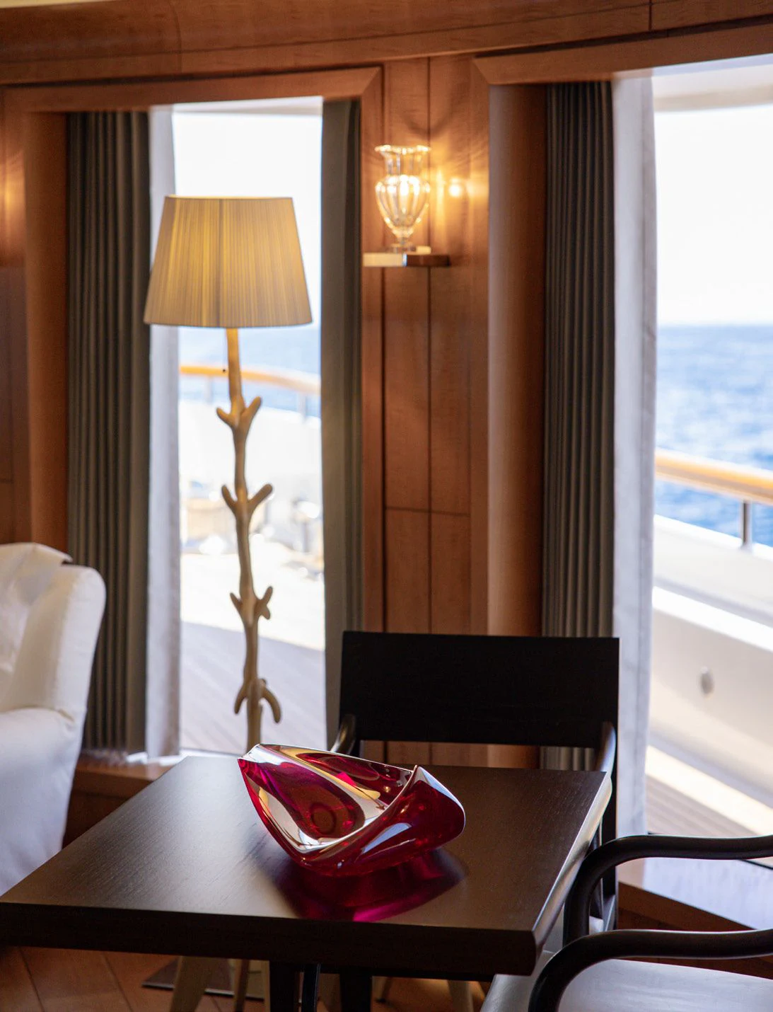 a table with chairs and a lamp aboard WEDGE TOO Yacht for Sale