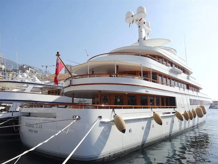 a large white boat with a statue on top aboard WEDGE TOO Yacht for Sale