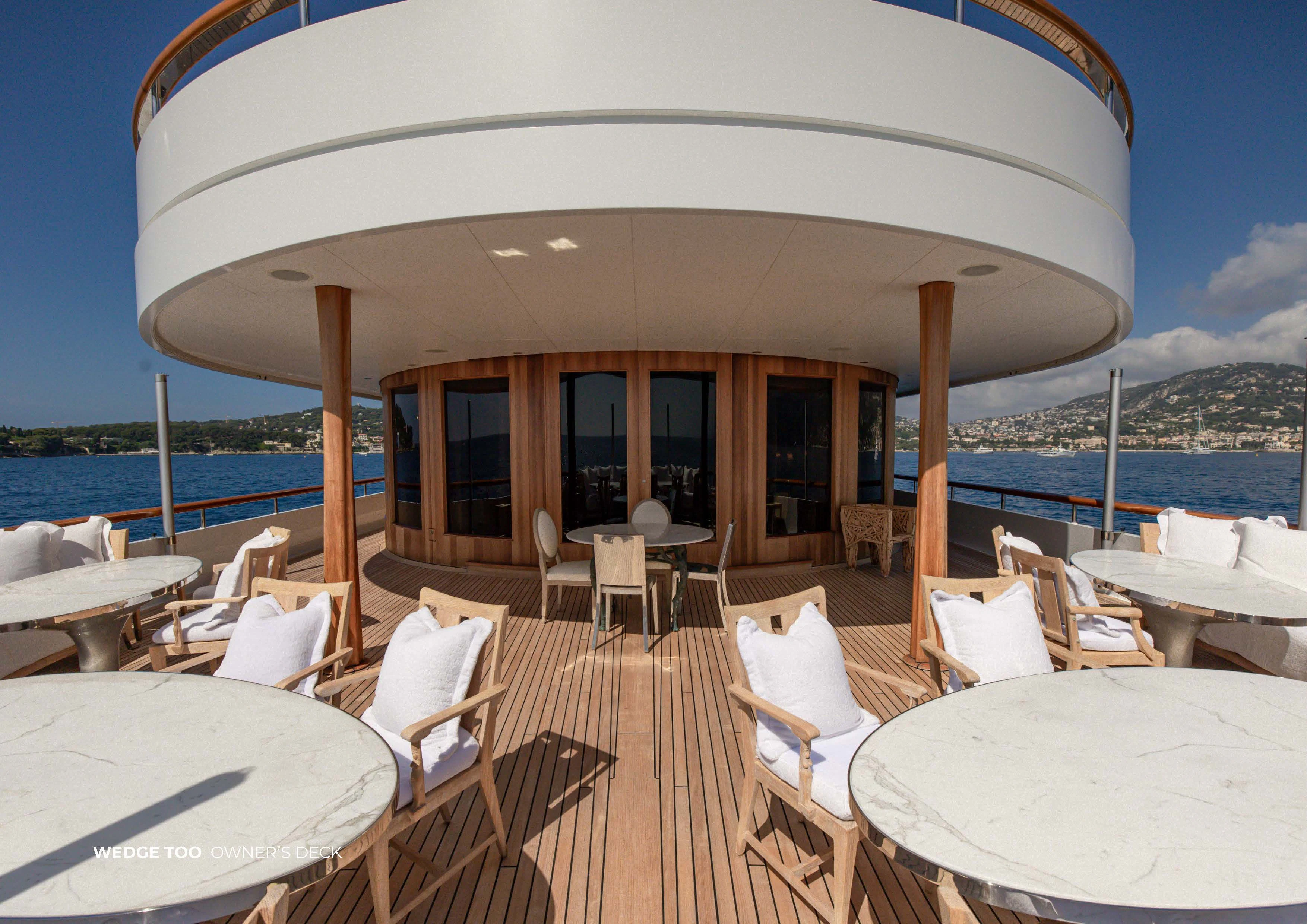 a patio with tables and chairs aboard WEDGE TOO Yacht for Sale