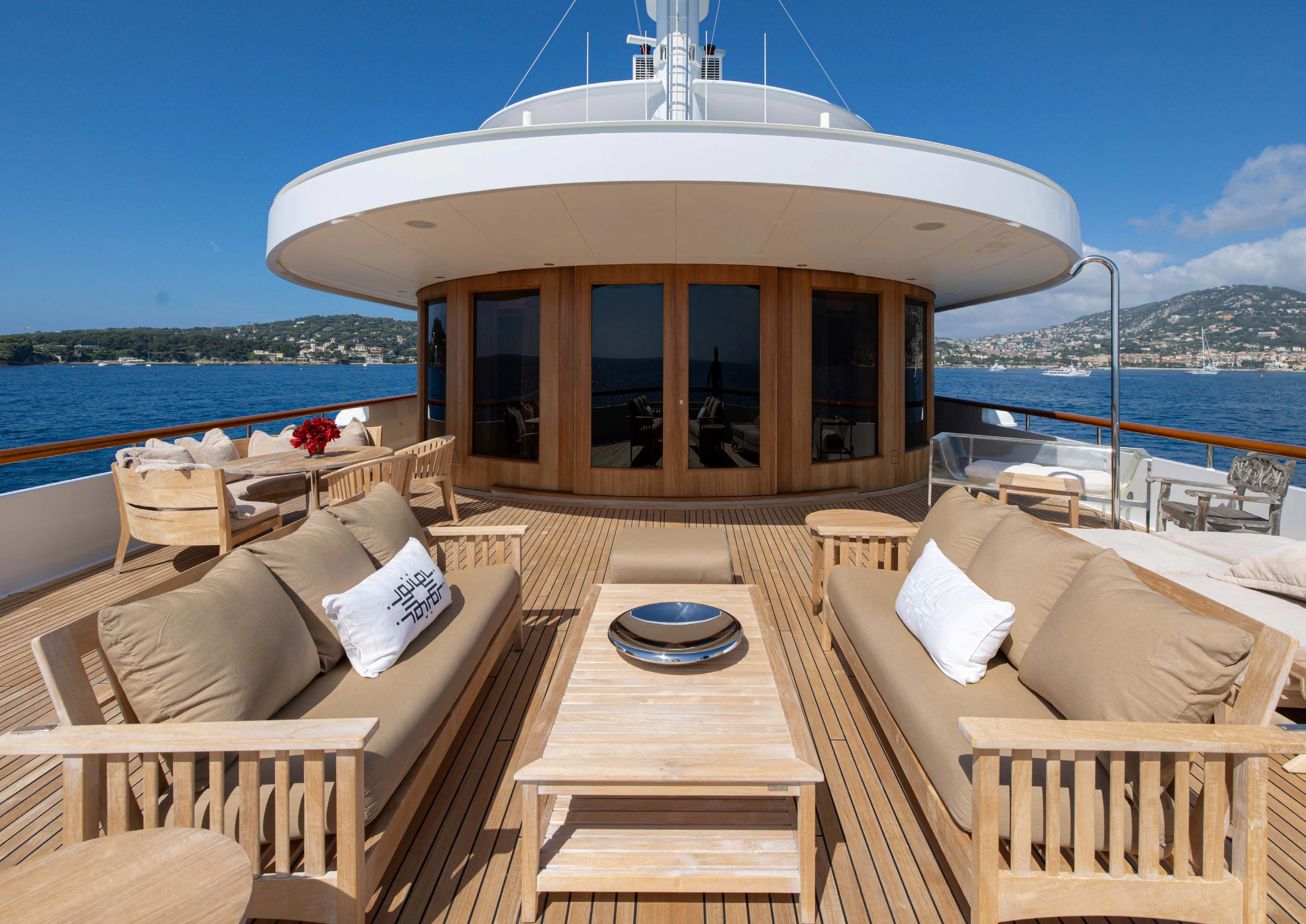 a deck with a view of the ocean and a large building aboard WEDGE TOO Yacht for Sale