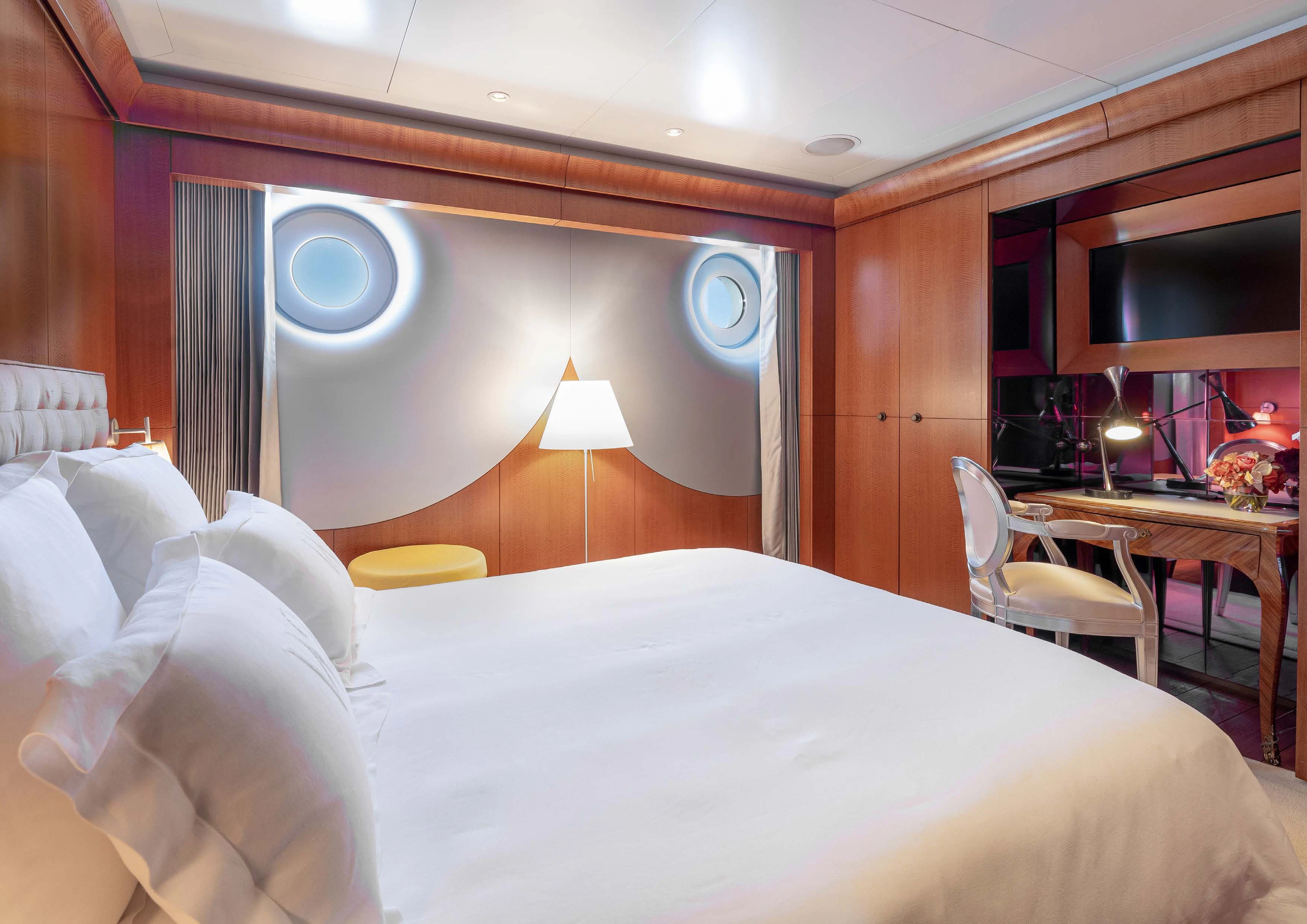 a hotel room with a bed and chairs aboard WEDGE TOO Yacht for Sale