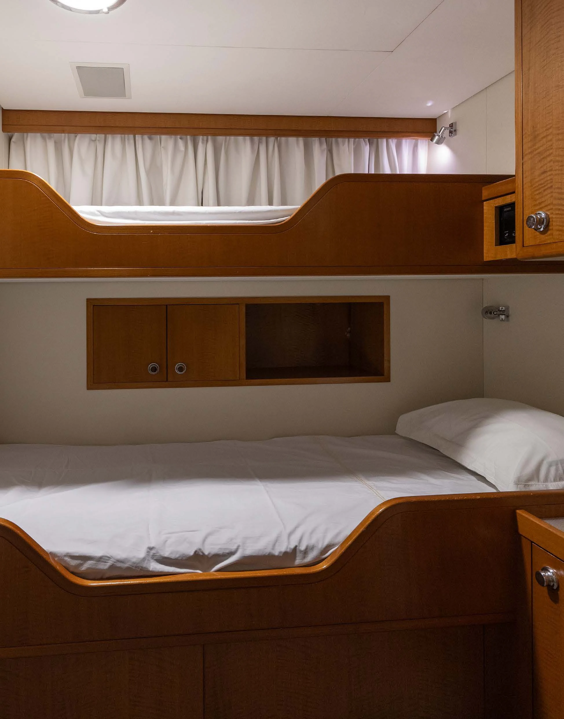 a bed with a television on the wall aboard WEDGE TOO Yacht for Sale
