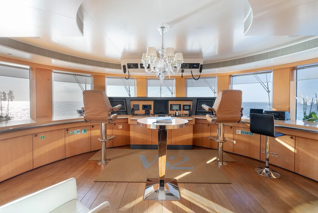 a room with a table chairs and a large chandelier aboard WEDGE TOO Yacht for Sale