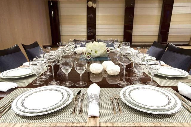 a table set with plates and glasses aboard FIVE Yacht for Sale