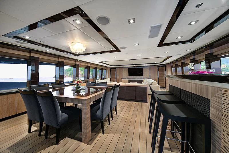 a room with tables and chairs aboard FIVE Yacht for Sale