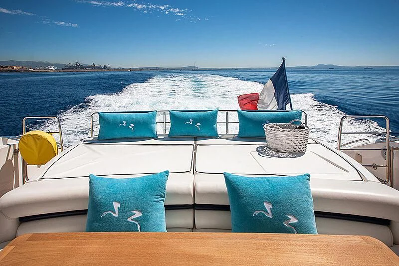 a boat with blue pillows on a deck with a view of the ocean aboard FROGGY Yacht for Sale