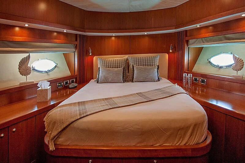 a bed with a white bed spread aboard FROGGY Yacht for Sale