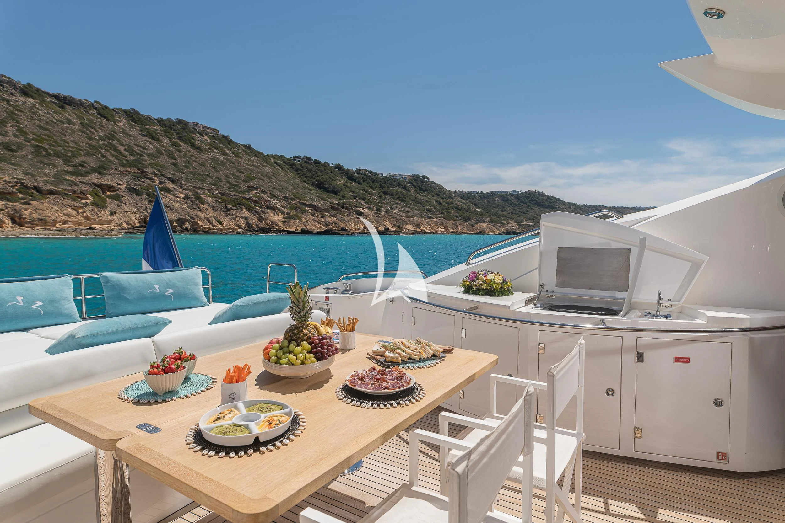 a table with food on it by the ocean aboard FROGGY Yacht for Sale