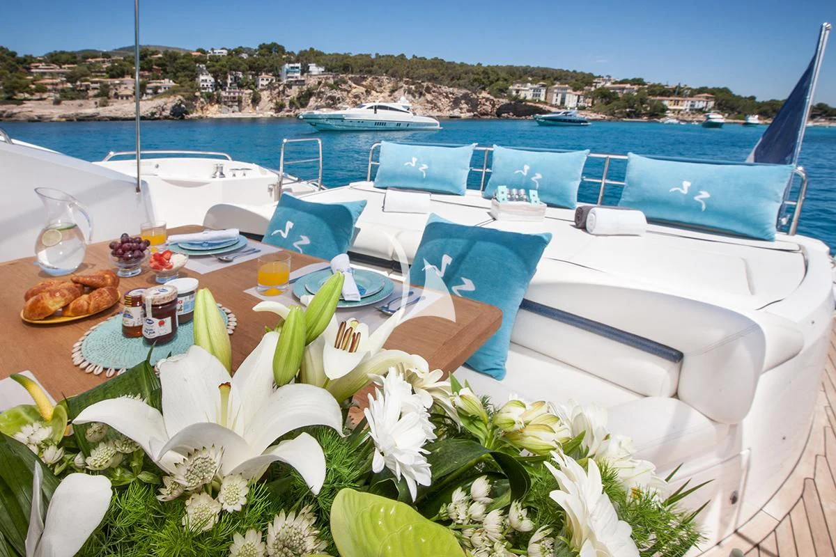 a table with chairs and flowers on it aboard FROGGY Yacht for Sale