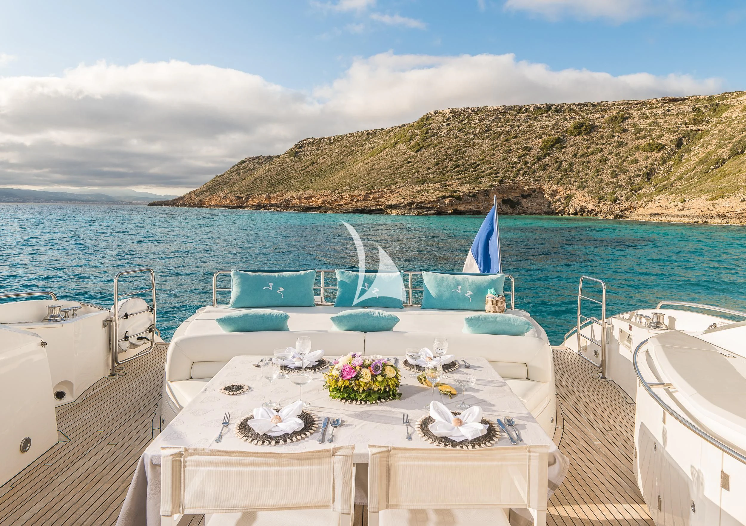 a table with flowers on it on a boat in the water aboard FROGGY Yacht for Sale
