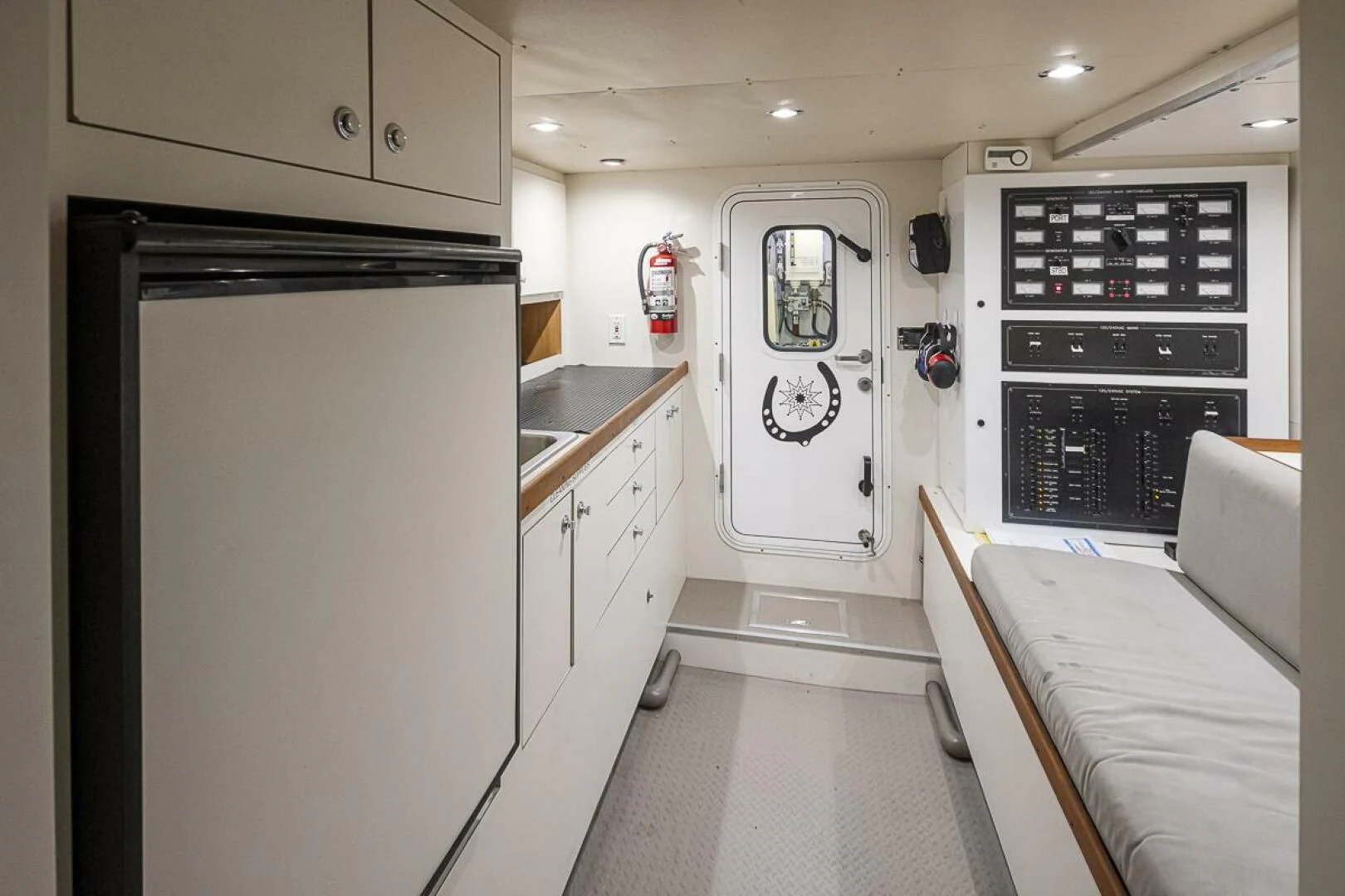 a small kitchen with a fridge aboard SEA SPUR Yacht for Sale