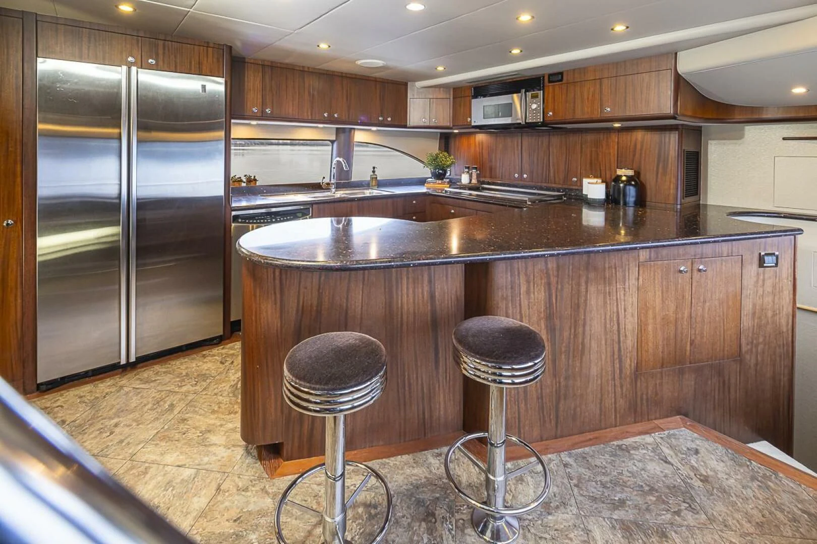 a kitchen with a bar stool and stools aboard SEA SPUR Yacht for Sale