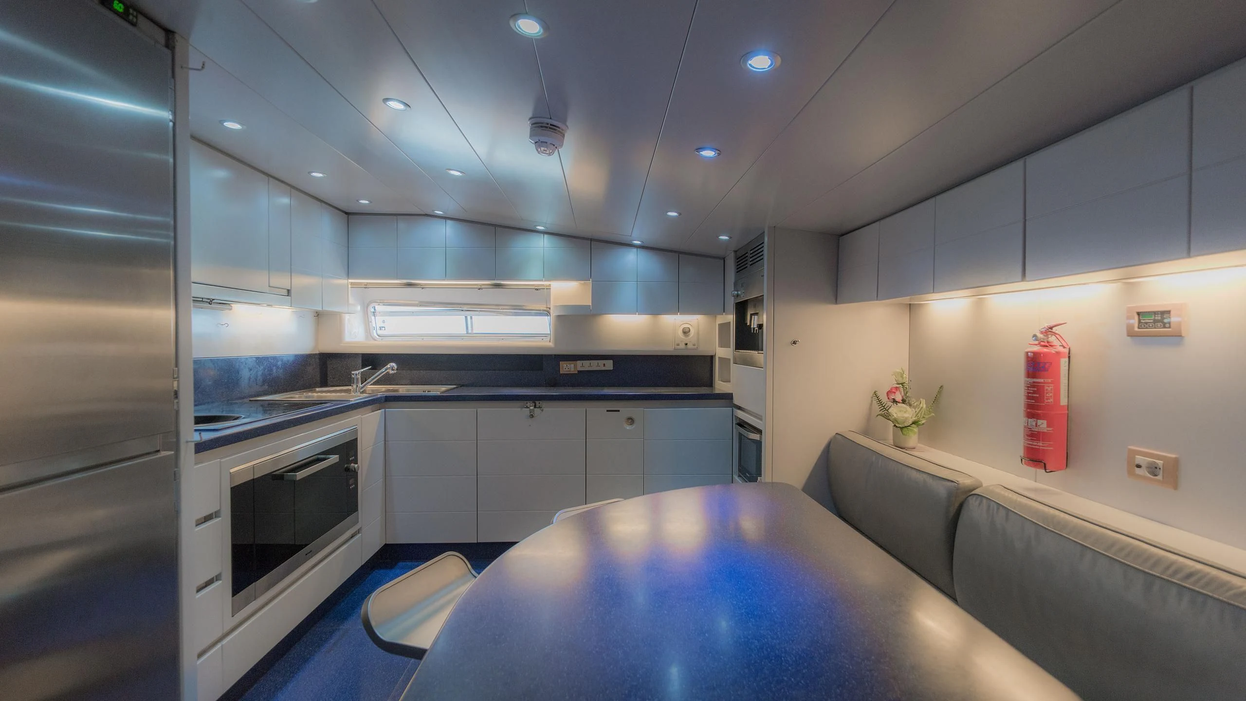 a kitchen with a table and a blue table aboard AVELINE Yacht for Sale
