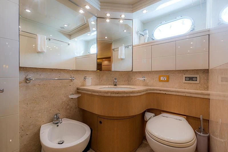a bathroom with a sink toilet and a mirror aboard AVELINE Yacht for Sale