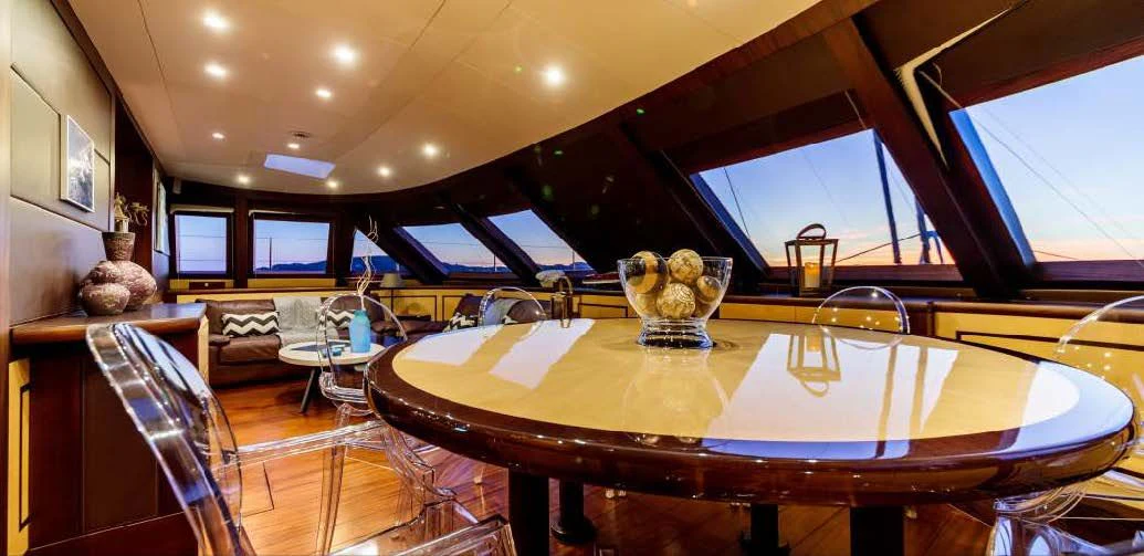 a large dining table in a room aboard ALLURES Yacht for Charter
