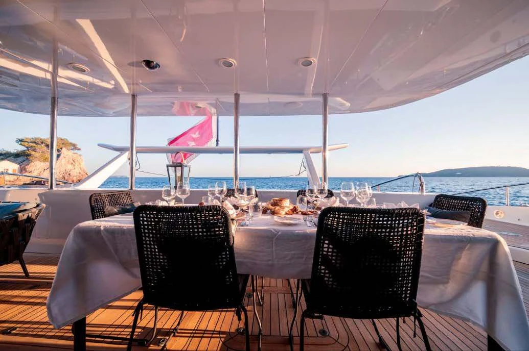 a table with chairs and a view of the ocean aboard ALLURES Yacht for Charter