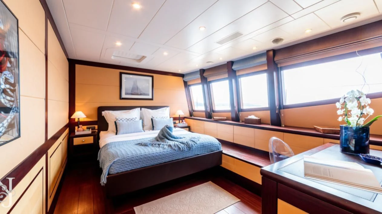 a room with a bed and a desk aboard ALLURES Yacht for Charter