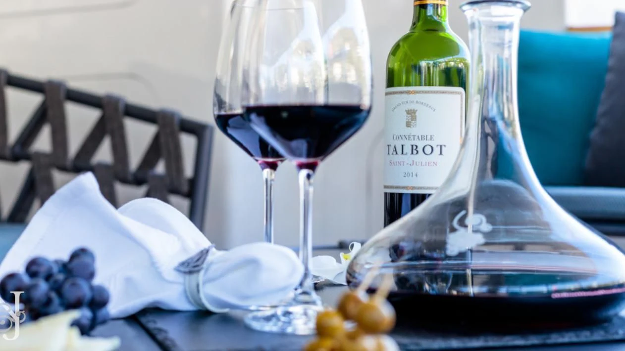 a wine bottle and glasses on a table aboard ALLURES Yacht for Charter