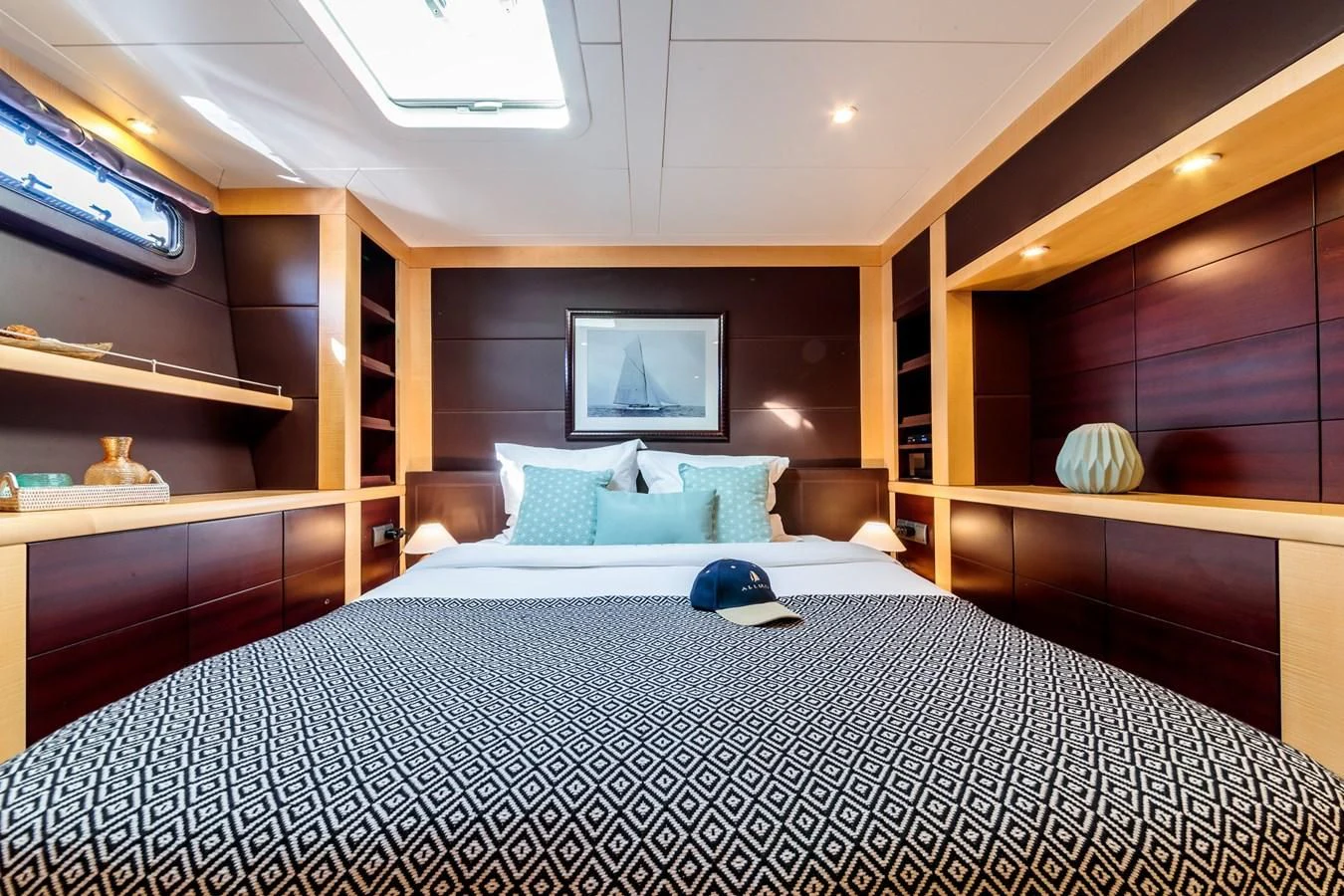 a bed with a blue pillow aboard ALLURES Yacht for Charter