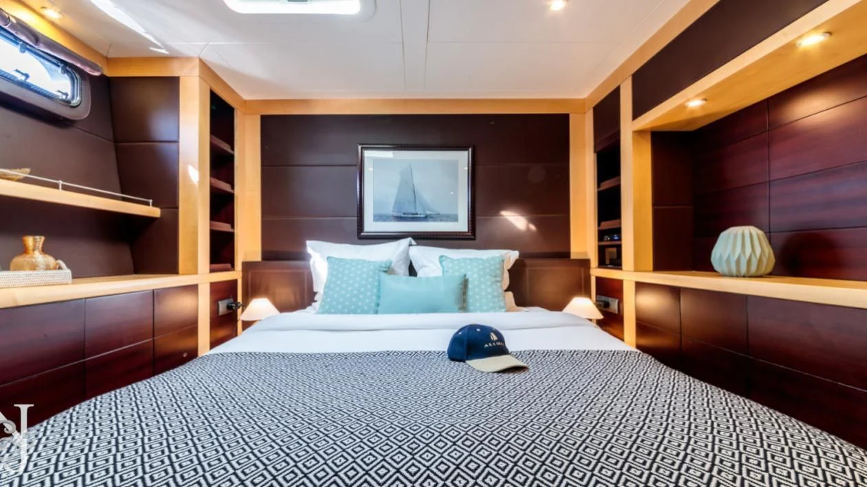 a bed with a television on the wall aboard ALLURES Yacht for Charter