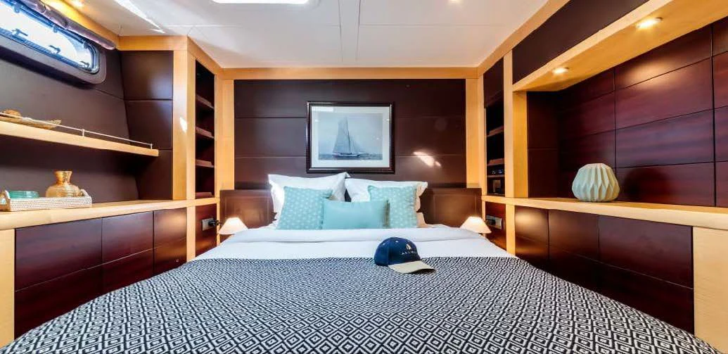 a bed with a black hat on it aboard ALLURES Yacht for Charter