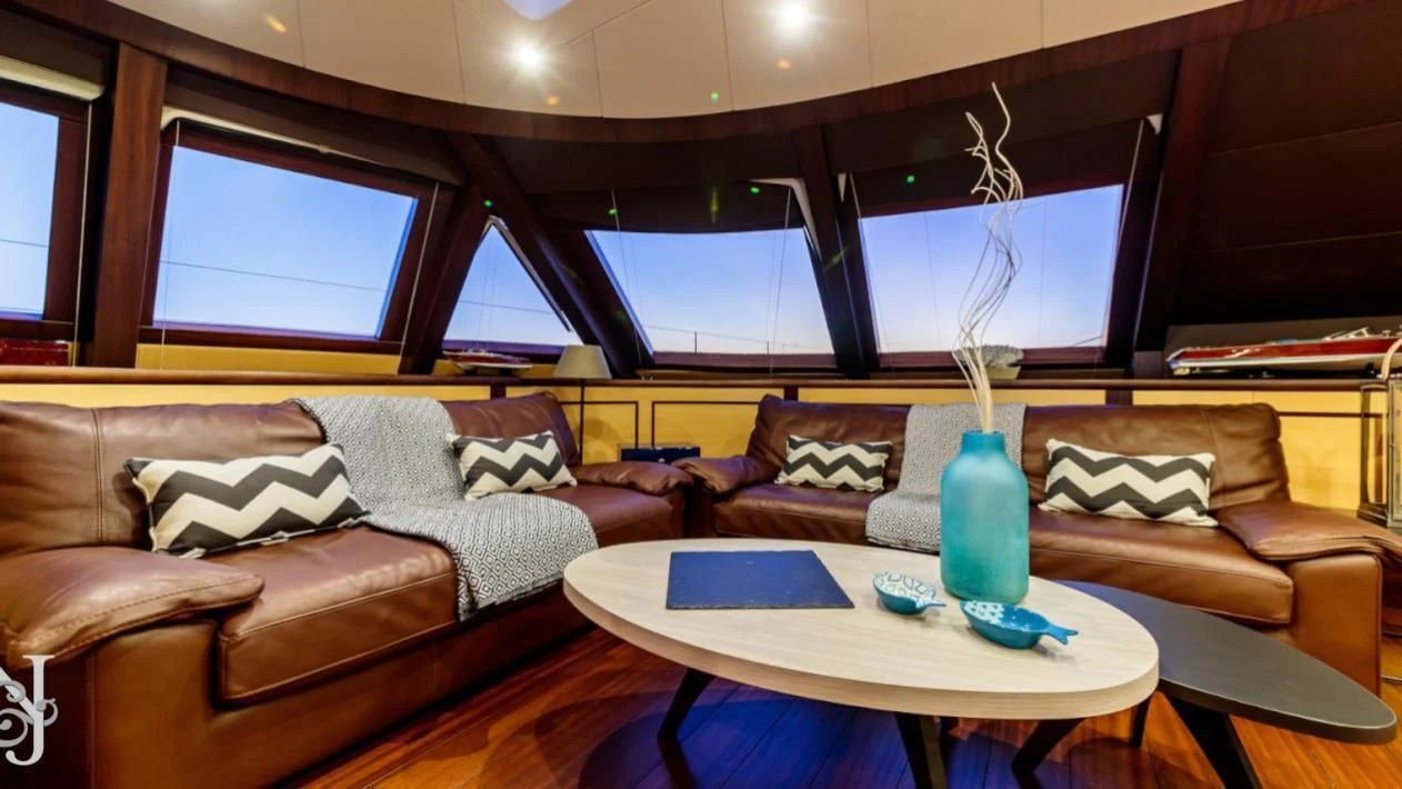a living room with a couch and a coffee table aboard ALLURES Yacht for Charter