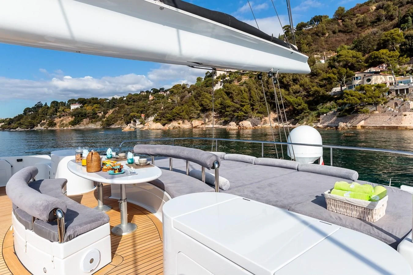 a deck with a table and chairs on it by a body of water aboard ALLURES Yacht for Charter