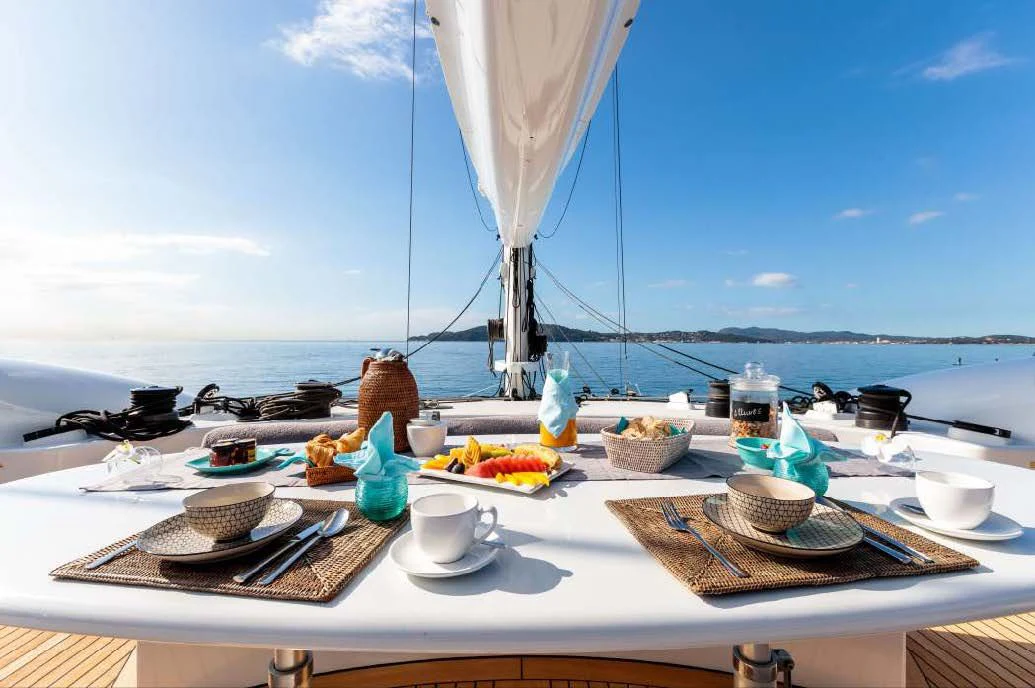 a table with plates and cups on it aboard ALLURES Yacht for Charter