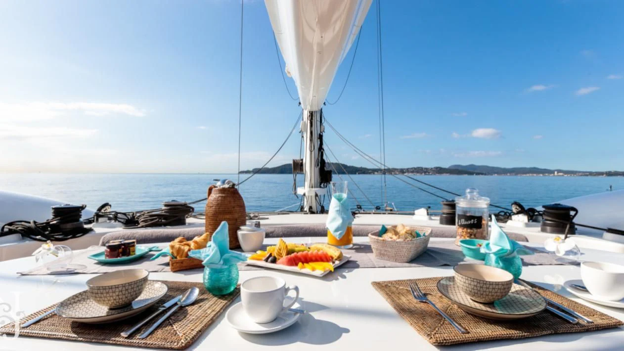 a table with food and drinks on it aboard ALLURES Yacht for Charter