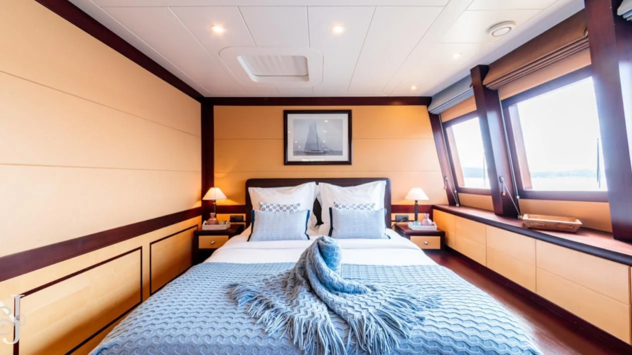 a room with a bed and a desk aboard ALLURES Yacht for Charter