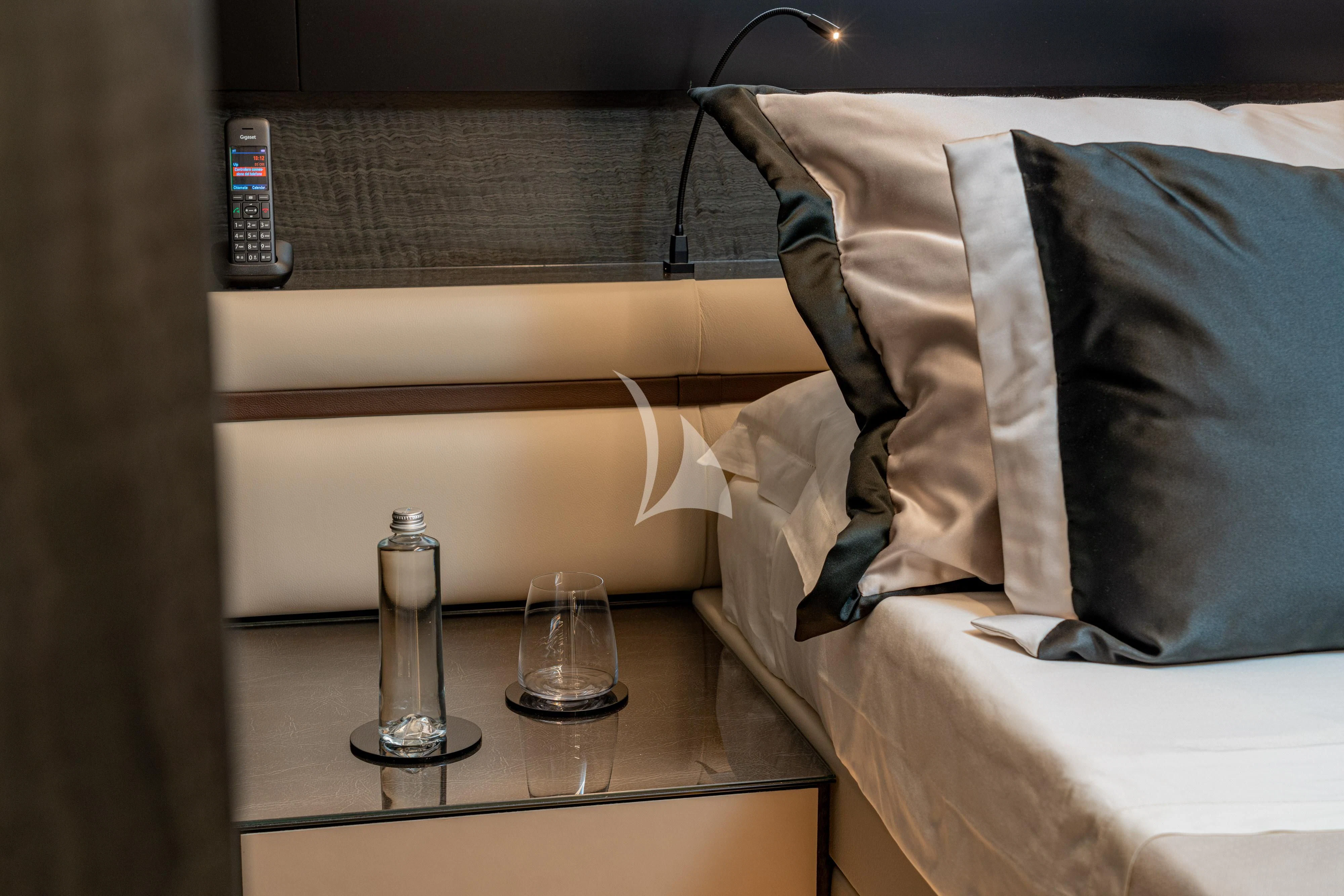 a bed with a lamp and a glass on it aboard SOPHIA Yacht for Sale