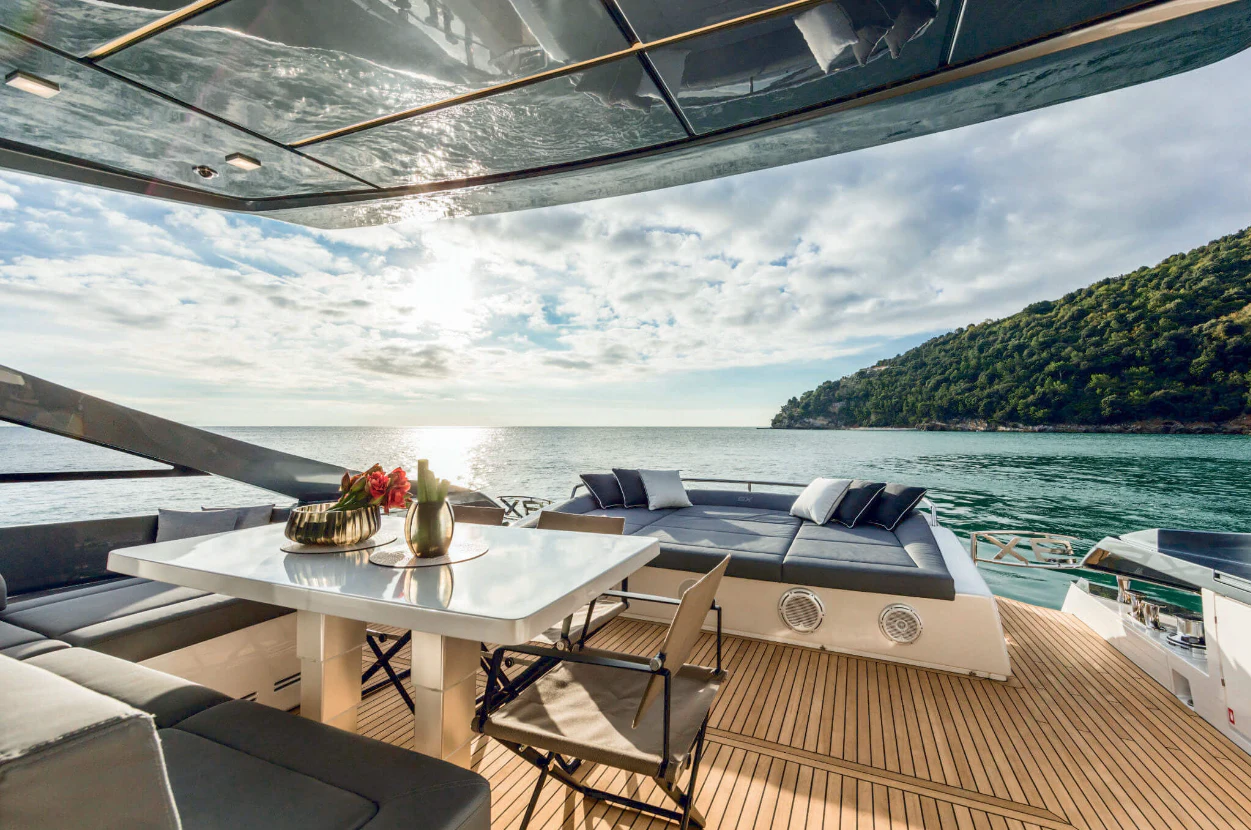 a deck with a table and chairs on it and a body of water in the background aboard SOPHIA Yacht for Sale