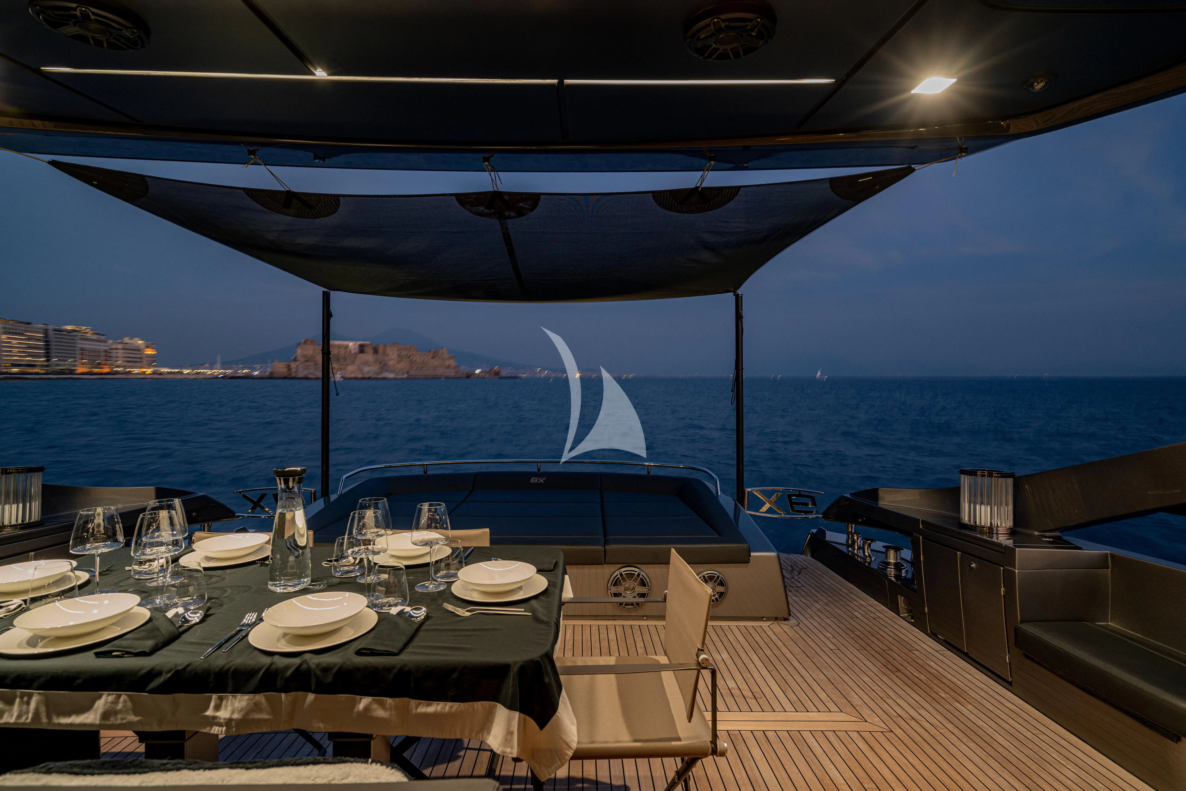 a table set for a dinner on a deck overlooking the ocean aboard SOPHIA Yacht for Sale