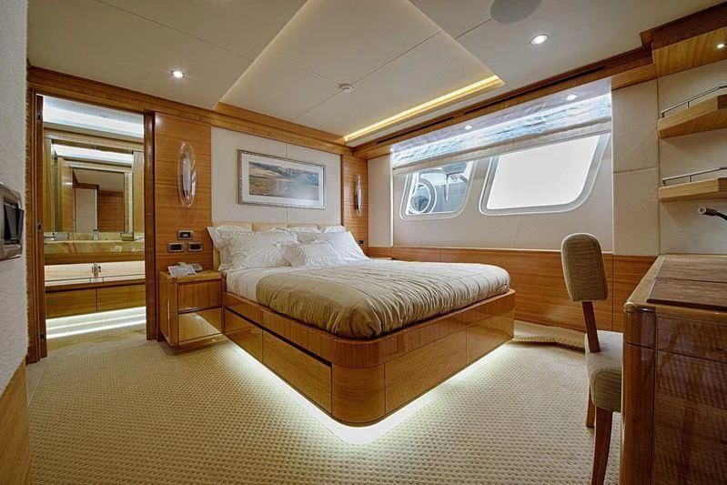 a bedroom with a bed and a desk aboard UAQ 1 Yacht for Sale