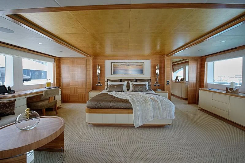a bedroom with a bed and a table aboard UAQ 1 Yacht for Sale
