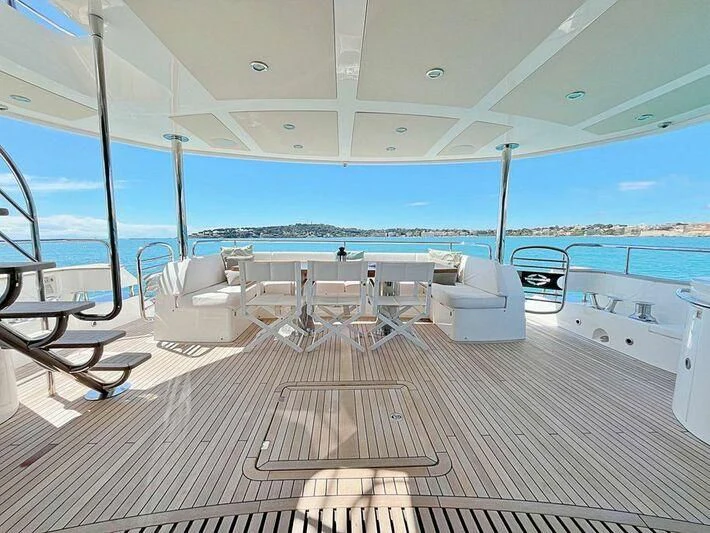 a deck with chairs and a table on it aboard RAY 3 Yacht for Sale