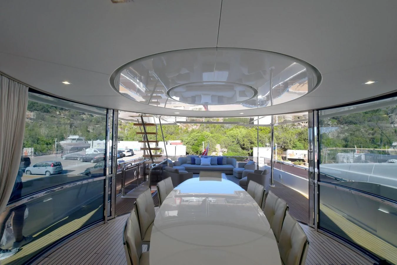 inside of a vehicle with a large round window and a table with chairs and a white table and aboard BLESSED ONE Yacht for Sale