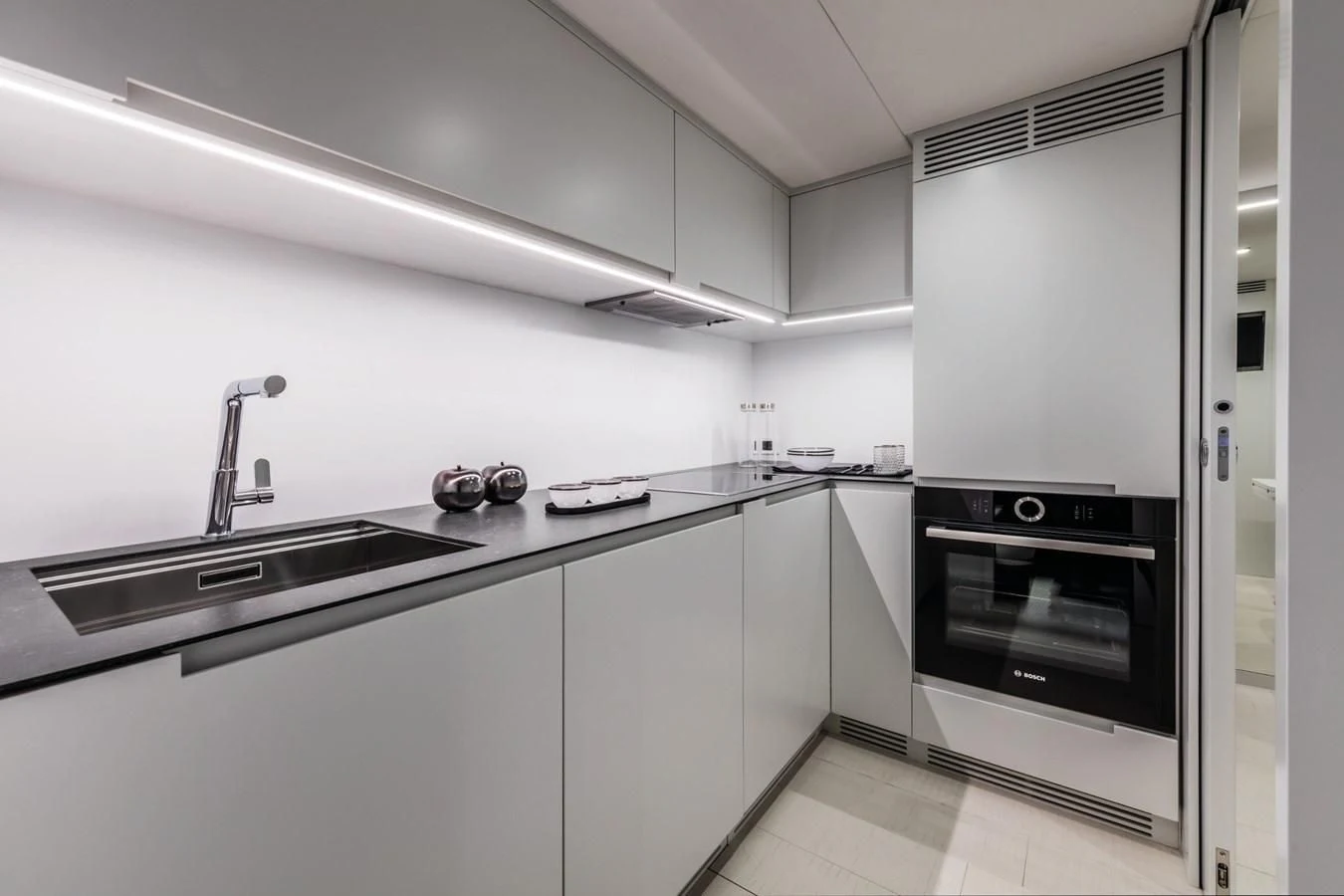 a kitchen with white cabinets aboard PERSHING 8X Yacht for Sale