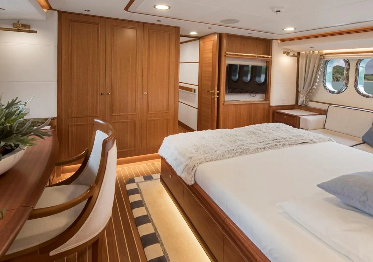 a bedroom with a bed and a chair aboard VALENCIA Yacht for Sale