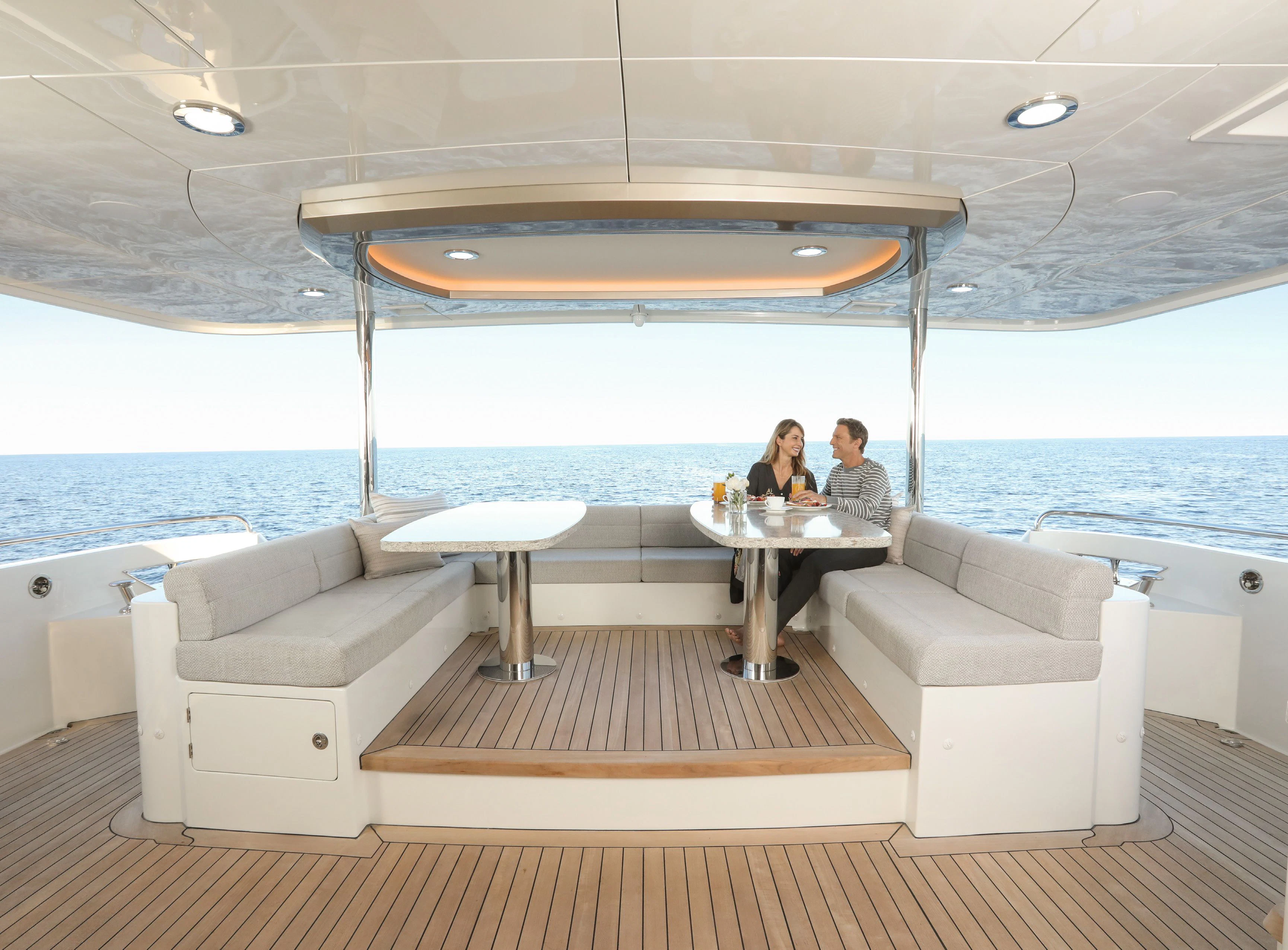 a couple sitting at a table on a boat in the water aboard OCEAN ALEXANDER 32L10 Yacht for Sale