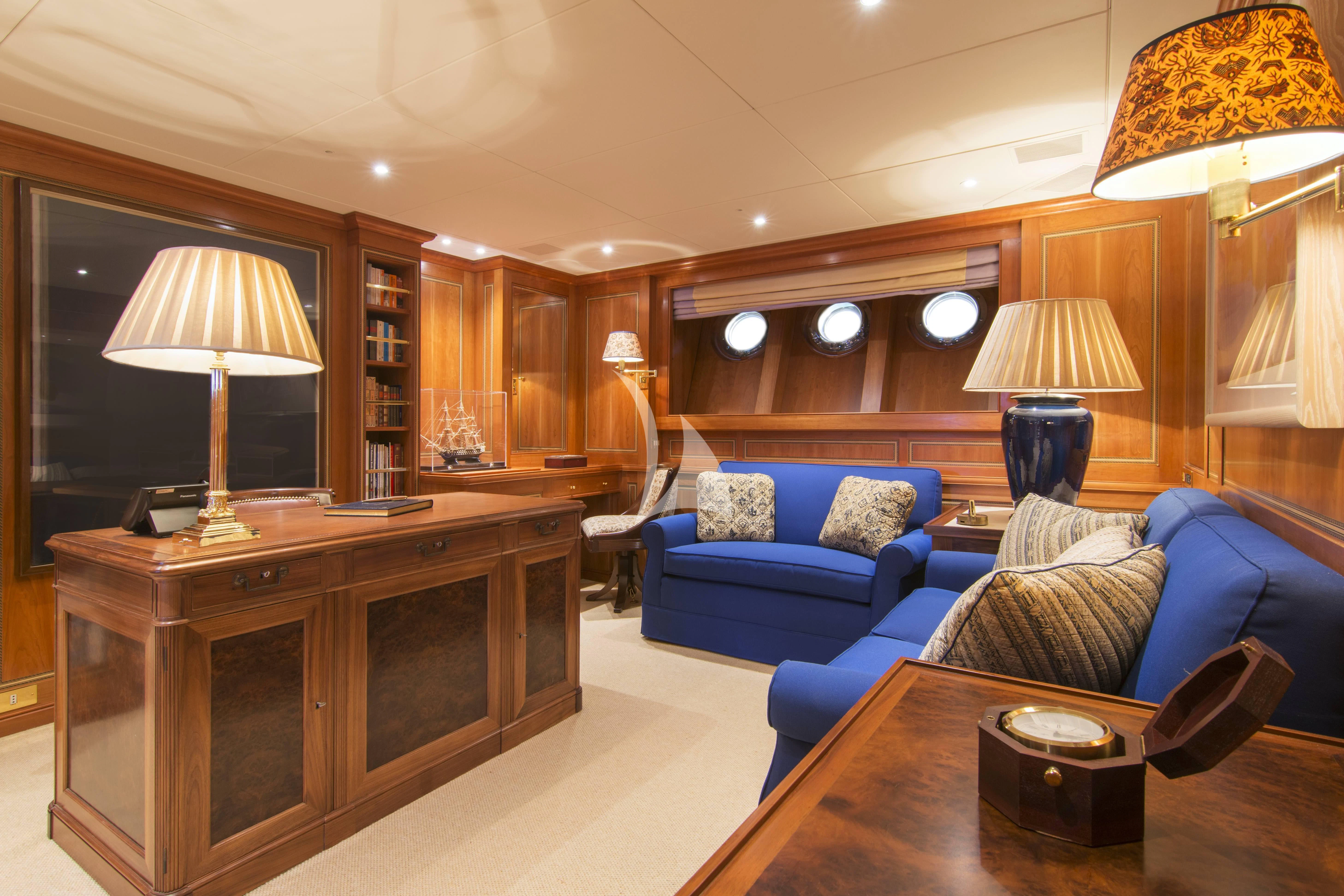 a living room with a blue couch aboard XASTERIA Yacht for Charter